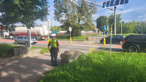Policjantka stoi przy przejściu dla pieszych.
