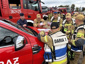 Strażacy oraz policjanci podczas omawiania działań