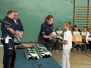 Policjantka wręcza kask uczniowi