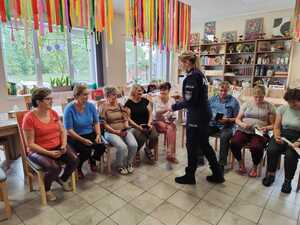 Policjantka rozdaje ulotki i odblaski