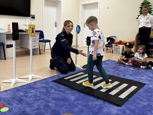 Policjantka tłumaczy dziecku jak należy przechodzić przez przejście