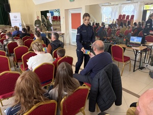 Policjantka rozdaje ulotki instruktarzowe